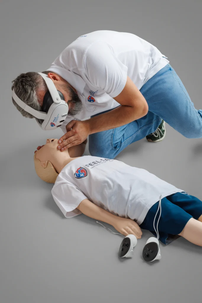 Instruktor CRR-PULS podczas szkolenia pierwszej pomocy VR wykonuje ocenę oddechu na fantomie z użyciem gogli wirtualnej rzeczywistości.